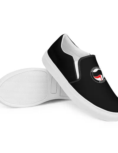 Step into activism with our Antifascist Action Men’s Slip-on Canvas Shoes. These sleek black shoes feature the iconic Antifa design, making a bold statement wherever you go. With elastic side accents for easy wear, a breathable lining keeps your feet comfortable all day long. The soft insole adds extra cushioning.